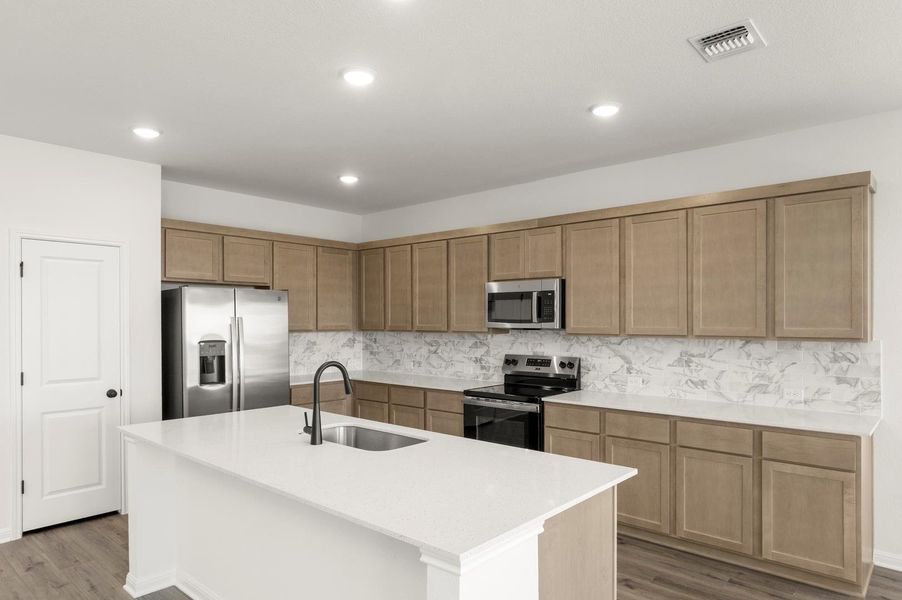 Kitchen featuring appliances with stainless steel finishes, decorative backsplash, dark wood-style flooring, light stone countertops, and recessed lighting