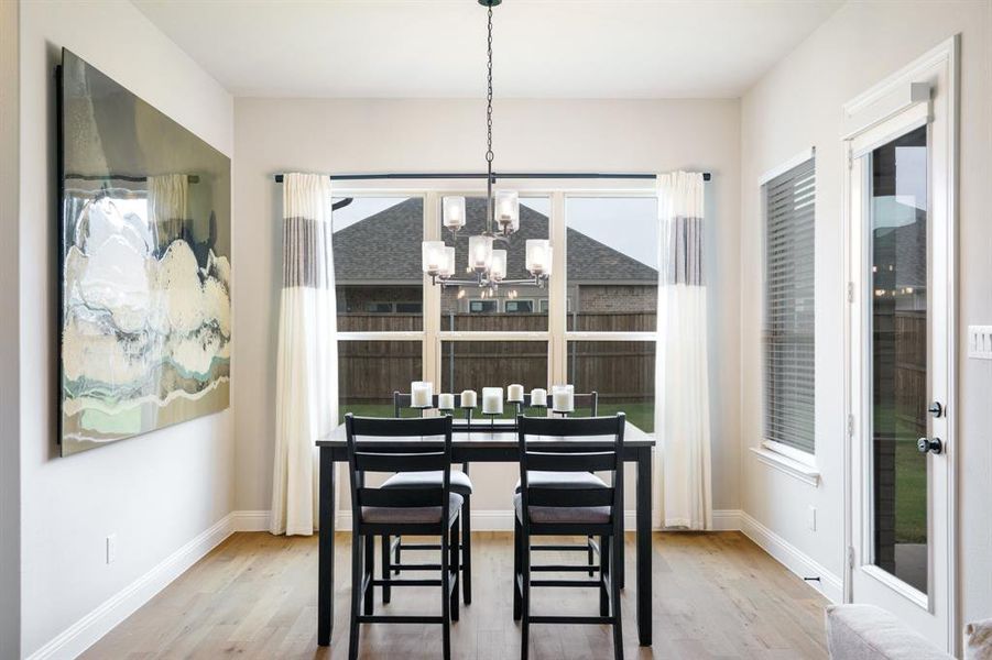 Dining space with a chandelier, wood finished floors, and baseboards Dining space with a chandelier, wood finished floors, and baseboards