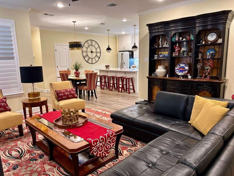 Living room featuring ornamental molding and light hardwood / wood-style floors