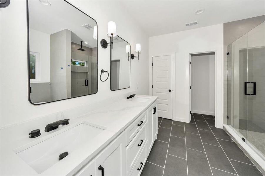 Bathroom featuring a shower stall, tile patterned floors, and double vanity Bathroom featuring a shower stall, tile patterned floors, and double vanity