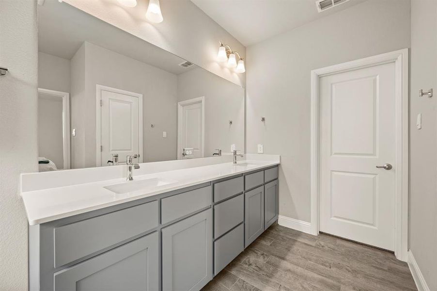Dual sink vanity with expansive counter space and framed mirror, perfect for getting ready with ease.