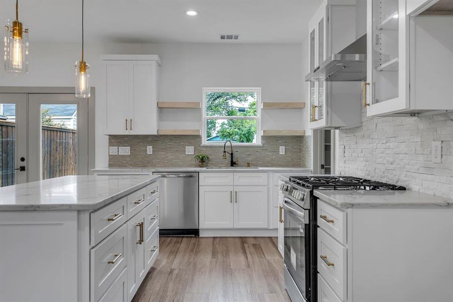 Kitchen featuring appliances with stainless steel finishes, white cabinetry, light stone countertops, pendant lighting, and recessed lighting Kitchen featuring appliances with stainless steel finishes, white cabinetry, light stone countertops, pendant lighting, and recessed lighting