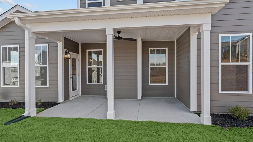 Vibrant rear outdoor space featuring a covered porch and exceptional craftsmanship