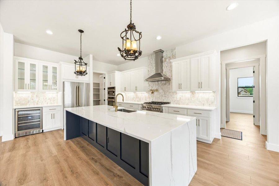 A chef's dream kitchen offers a large island, premium appliances, and warm wood flooring.