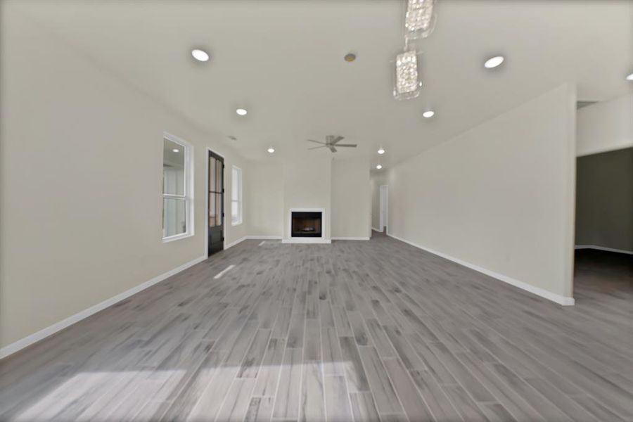 Unfurnished living room featuring wood finished floors, ceiling fan, recessed lighting, and a fireplace