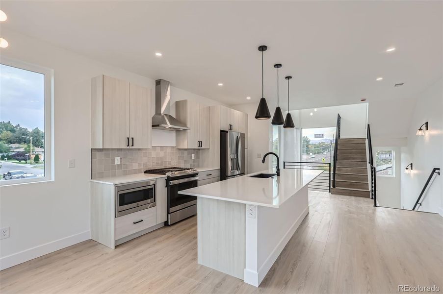 Island with seating, gas cooktop, stainless appliances, quartz countertops(NOTE: This home has a darker color scheme. See finishes for details.)