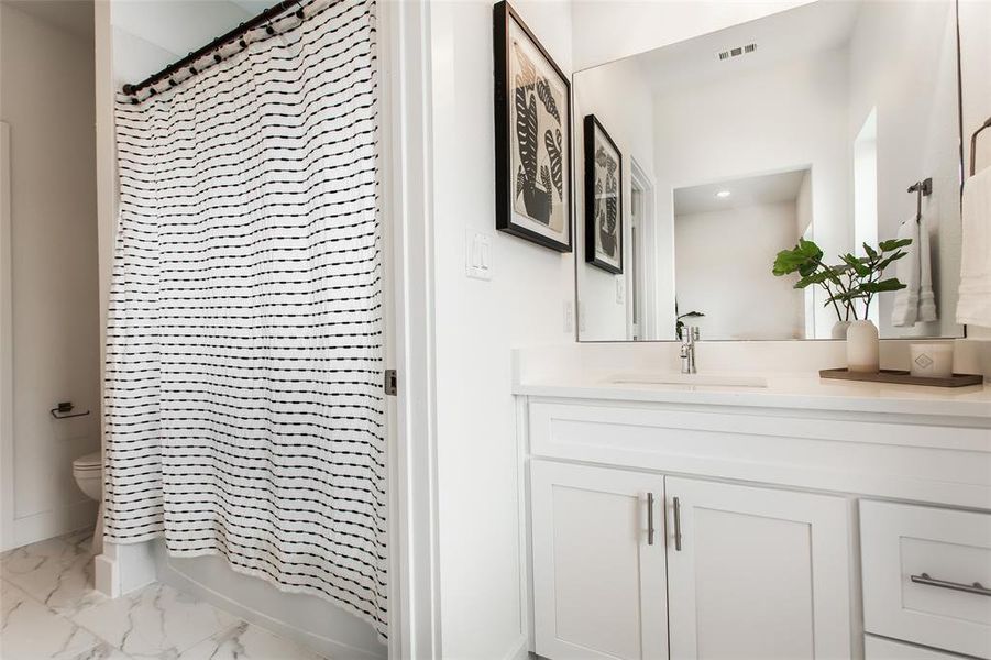 Full bathroom featuring vanity, shower / bath combination with curtain, and toilet