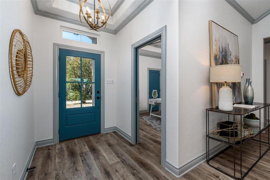 Bright entryway with designer paint color door and trim work.