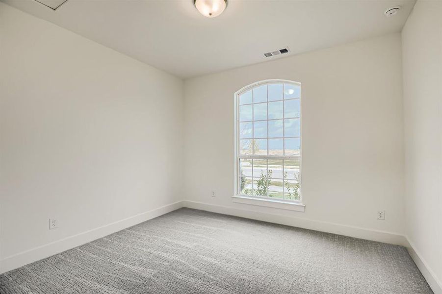 Unfurnished room featuring light carpet and baseboards