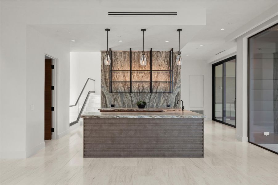Polished tile flooring and custom stone surfaces define this modern built-in wet bar area. Polished tile flooring and custom stone surfaces define this modern built-in wet bar area.