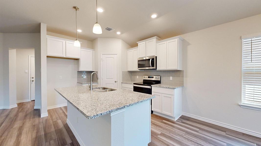 Kitchen featuring white cabinets, light stone counters, light wood-type flooring, and decorative backsplash Kitchen featuring white cabinets, light stone counters, light wood-type flooring, and decorative backsplash