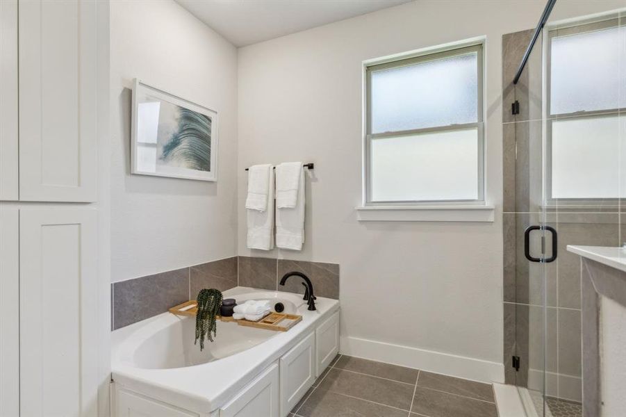 Bathroom featuring independent shower and bath and tile patterned flooring