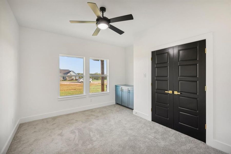 Unfurnished bedroom with ceiling fan, light carpet, and a closet