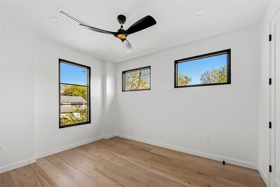 Empty room featuring light wood-type flooring, a ceiling fan, and recessed lighting