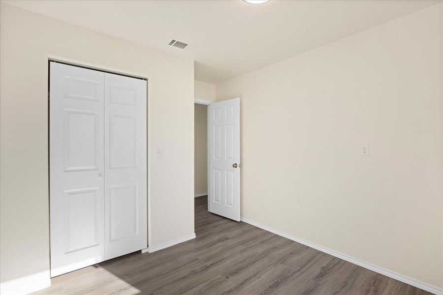 Unfurnished bedroom featuring hardwood / wood-style flooring and a closet