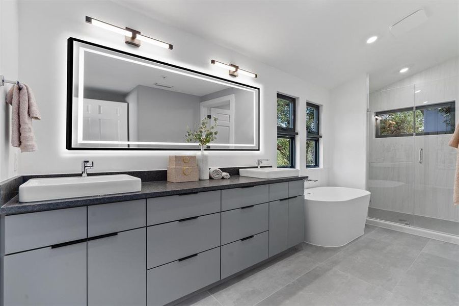 Principal bathroom with a soaking tub, glass-enclosed shower, dual vanities, and high-end fixtures.