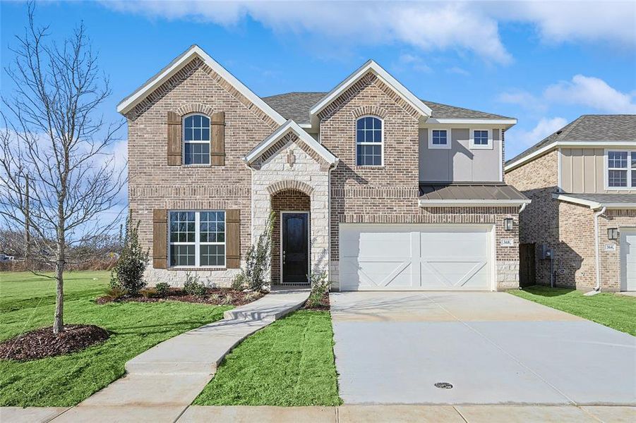 View of front of home featuring a garage and a front lawn