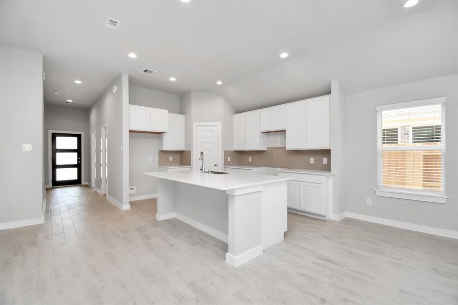 Discover another perspective of this stunning kitchen, generously appointed with an abundance of counter space. Sample photo of similar plan. As-built color and selections may vary.