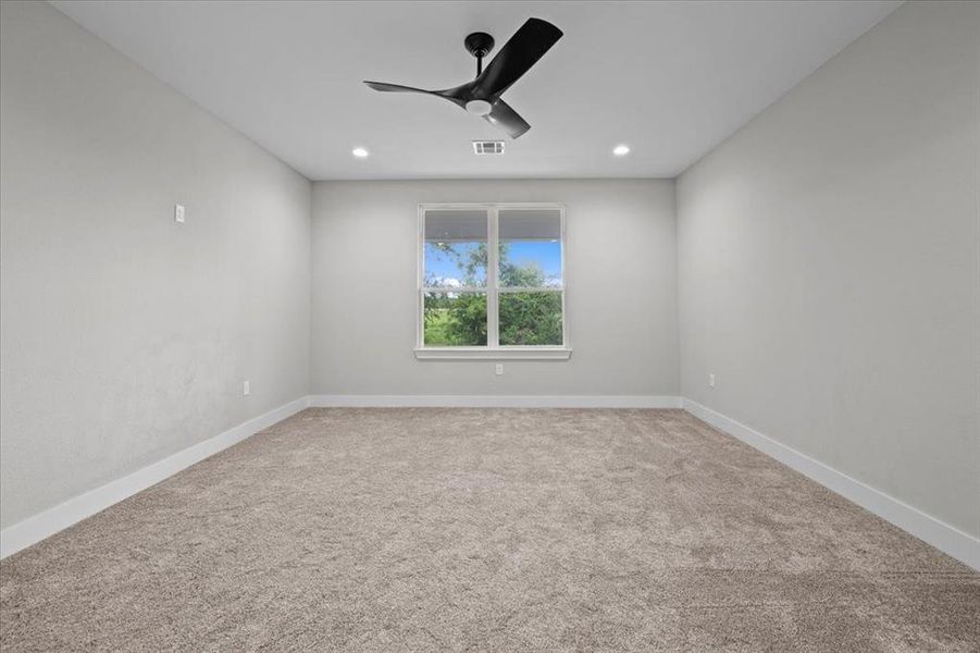 Carpeted empty room featuring a ceiling fan and recessed lighting