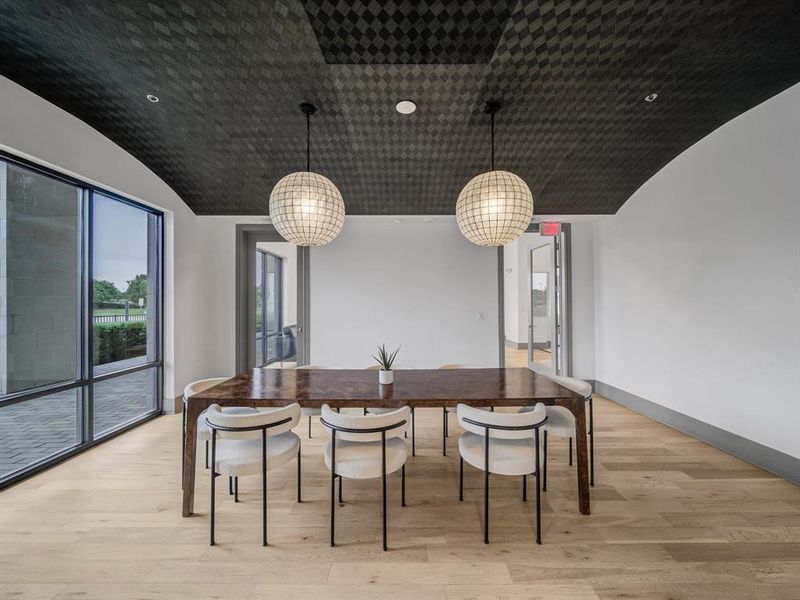 Dining area featuring light wood finished floors, vaulted ceiling, and recessed lighting