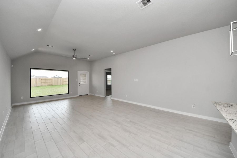 Gather the family and guests together in your lovely living room! Featuring soaring high ceilings, recessed lighting, ceiling fan, custom paint, gorgeous floors, and large windows that provide plenty of natural lighting throughout the day. Sample photo of completed home with similar floor plan. Actual colors and selections may vary.