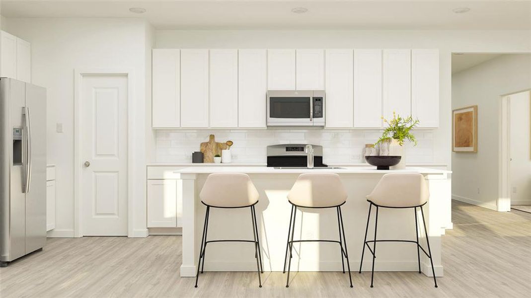 Kitchen with appliances with stainless steel finishes, light wood-type flooring, a breakfast bar, a center island with sink, and white cabinetry