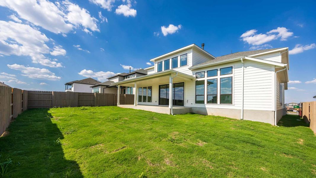 Rear view of house featuring a patio area and a fenced backyard