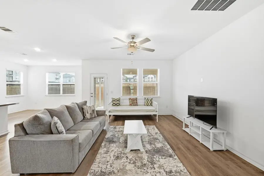 Living area with a ceiling fan and light wood-style floors