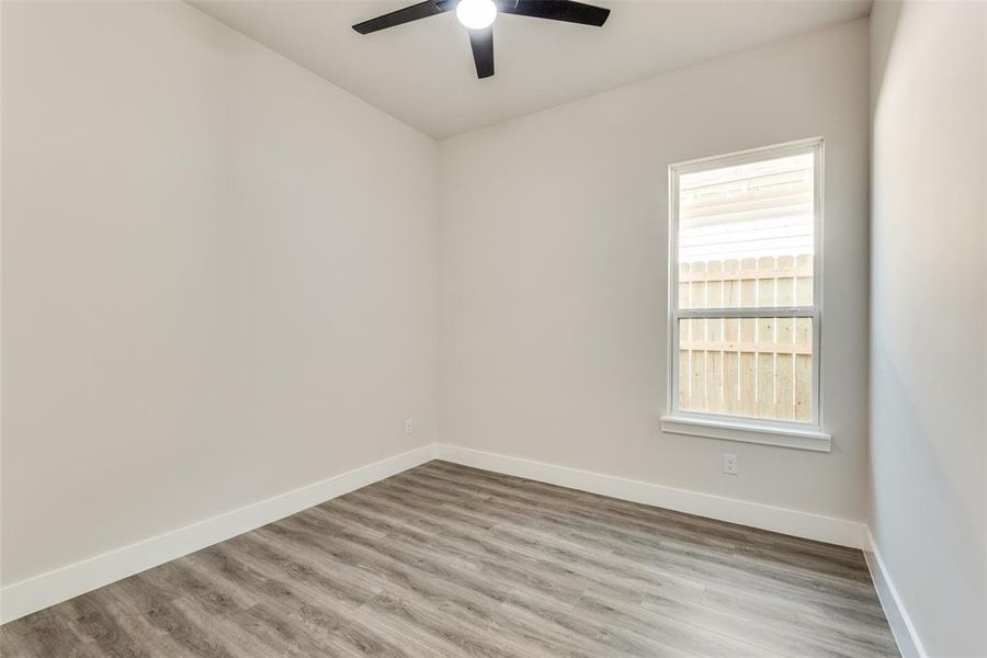 Empty room with hardwood / wood-style flooring and ceiling fan