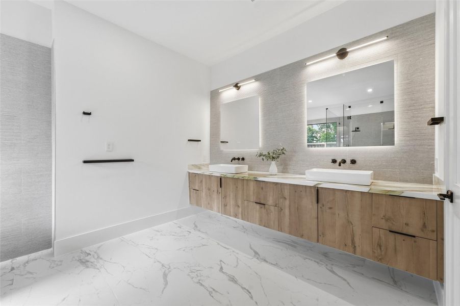 A spa-inspired primary bath with a freestanding soaking tub, floating dual vanity, oversized mirrors, and a spacious glass-enclosed shower.