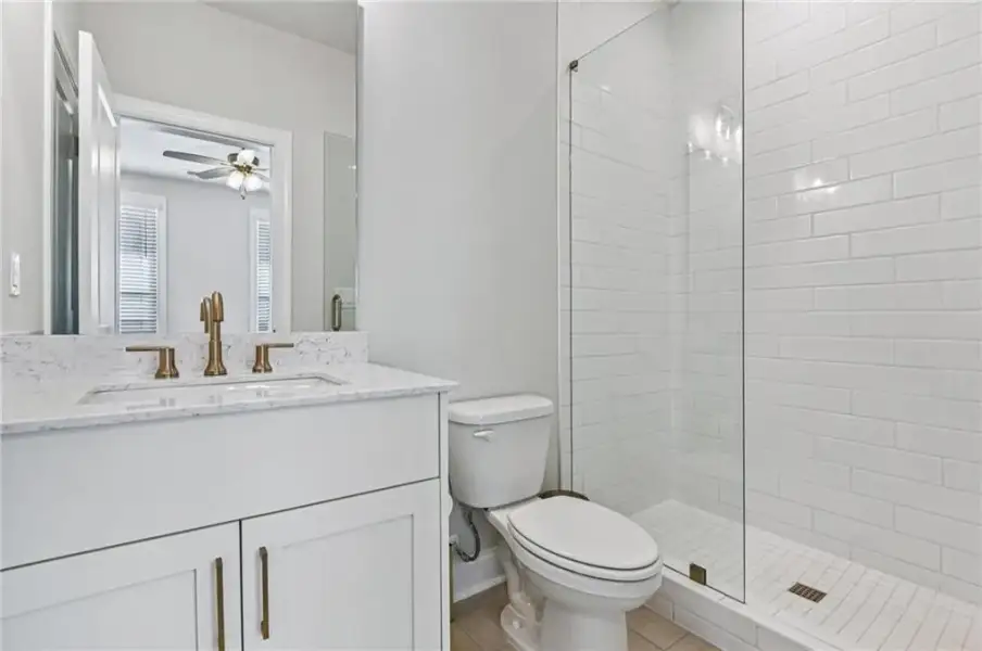 Full bath featuring vanity, a stall shower, light tile patterned floors, and a ceiling fan ~ Photos shown are of previously finished home and for viewing purpose only ~ Full bath featuring vanity, a stall shower, light tile patterned floors, and a ceiling fan ~ Photos shown are of previously finished home and for viewing purpose only ~