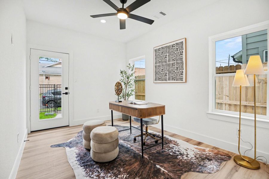 This bright, modern home office (or secondary bedroom) features large windows, a glass door for natural light, and a full walk-in close, and bathroom.
