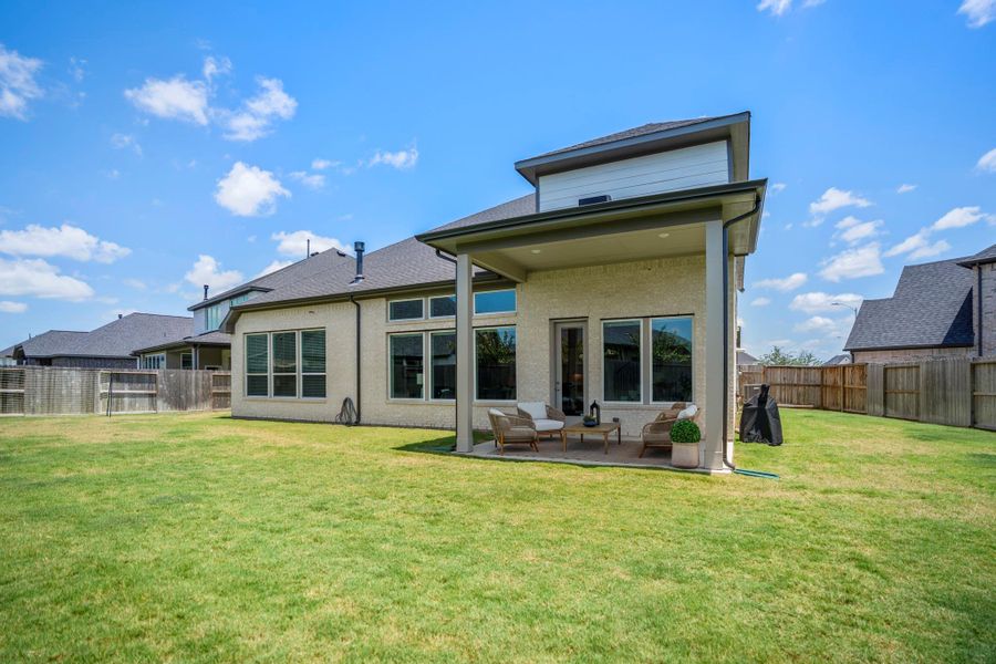 The covered patio opens to an expansive fenced backyard with plenty of room for outdoor dining, weekend barbecues, yard games and relaxed evenings under the big Texas sky.