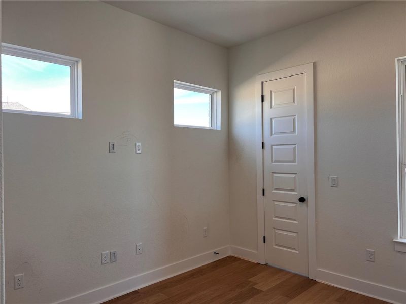 Empty room with dark wood-type flooring and baseboards