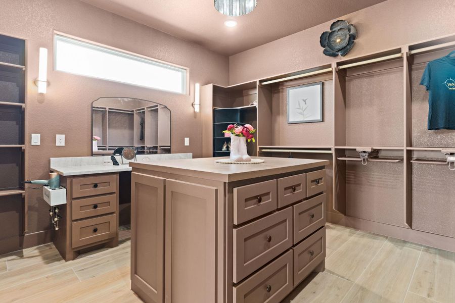 Spacious closet with light wood-style floors Spacious closet with light wood-style floors