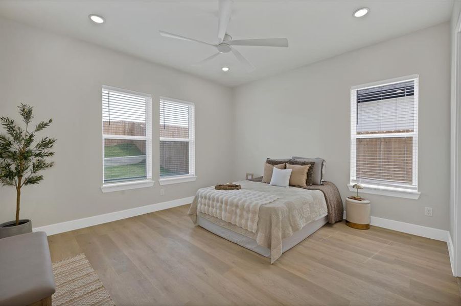 Bedroom with baseboards, light wood-style floors, recessed lighting, and ceiling fan Bedroom with baseboards, light wood-style floors, recessed lighting, and ceiling fan