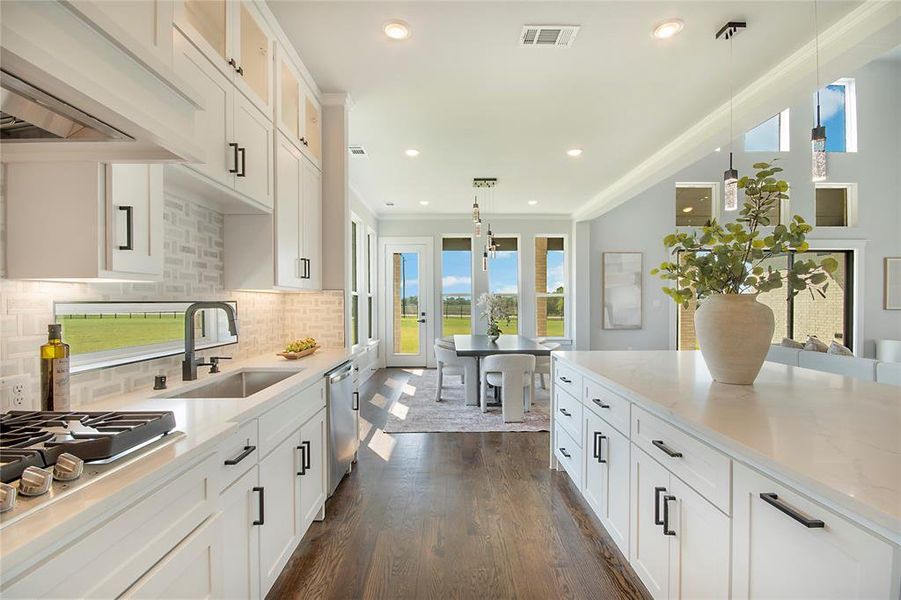 Kitchen featuring white cabinetry, decorative light fixtures, decorative backsplash, exhaust hood, and recessed lighting Kitchen featuring white cabinetry, decorative light fixtures, decorative backsplash, exhaust hood, and recessed lighting