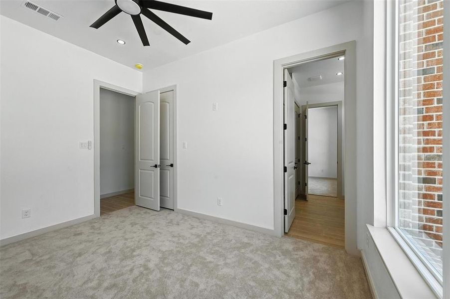 Unfurnished bedroom with carpet flooring, recessed lighting, ceiling fan, and wood finished floors Unfurnished bedroom with carpet flooring, recessed lighting, ceiling fan, and wood finished floors
