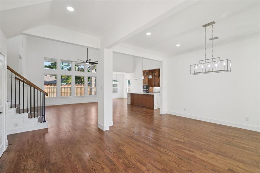 Unfurnished living room featuring a ceiling fan, dark real-wood floors, stairs, and recessed lighting