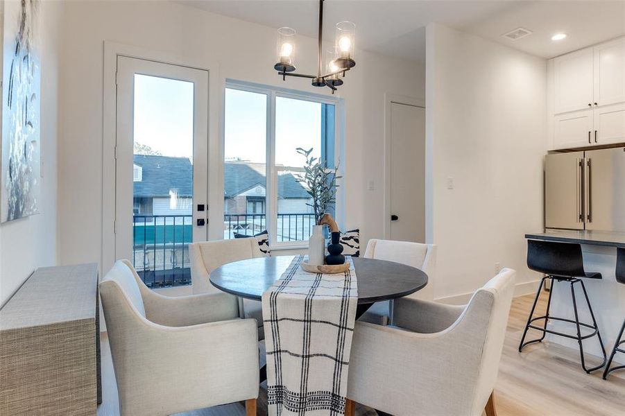 Dining space with light hardwood / wood-style floors and an inviting chandelier