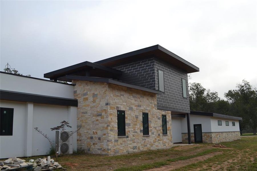 View of side of home with stone siding and stucco siding View of side of home with stone siding and stucco siding