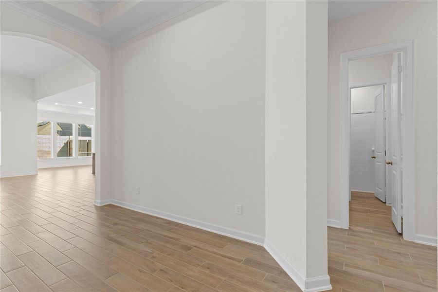 A closer look at the entry and adjacent living space showcases the open concept layout and clean architectural lines, offering flexibility for furniture placement and decor, with high ceilings and quality finishes that set the tone for the comfortable and stylish living found throughout the home.