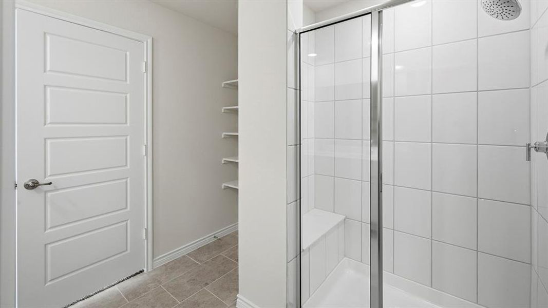 Bathroom with a shower stall and light tile patterned floors Bathroom with a shower stall and light tile patterned floors