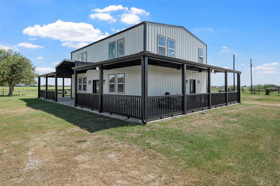 View of side of home with a lawn, a ceiling fan, and a large porch View of side of home with a lawn, a ceiling fan, and a large porch