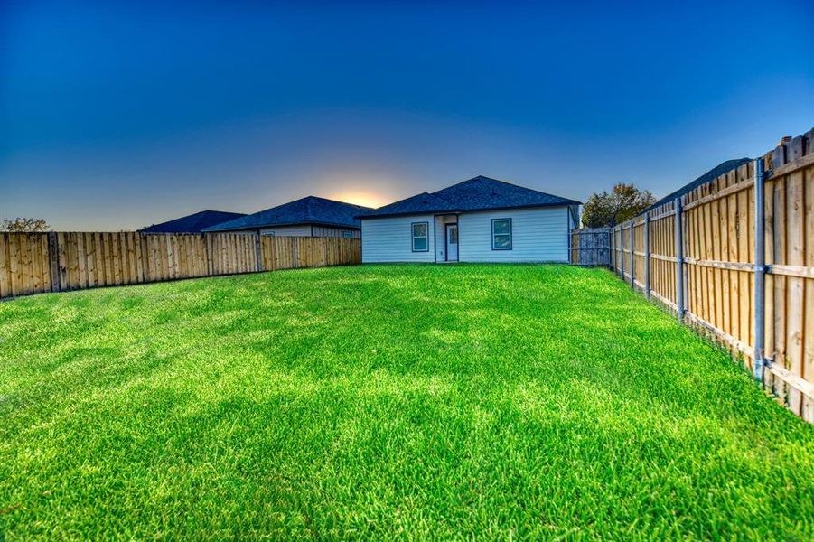 Rear view of property with a fenced backyard
