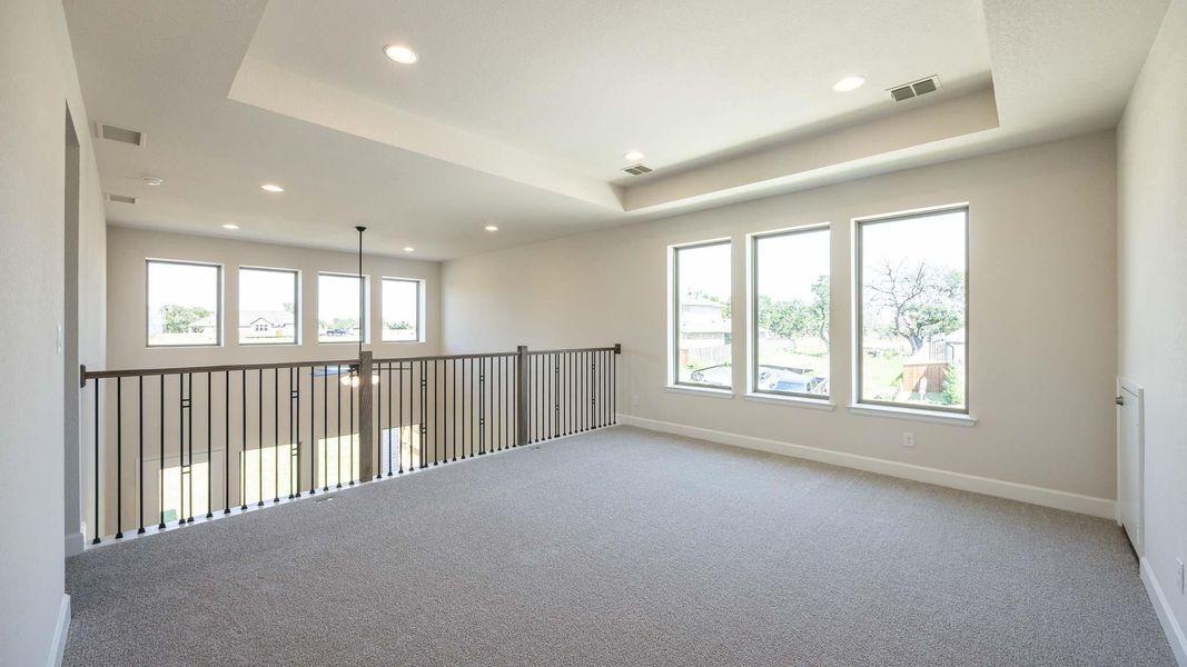 Carpeted empty room featuring a raised ceiling and recessed lighting