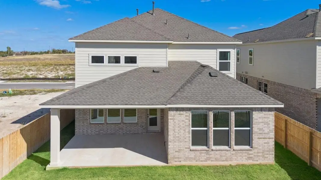 Back of house with a fenced backyard, a shingled roof, a patio area, and brick siding