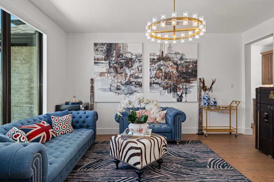 An inviting living area features hardwood floors and a statement chandelier, perfect for entertaining. An inviting living area features hardwood floors and a statement chandelier, perfect for entertaining.