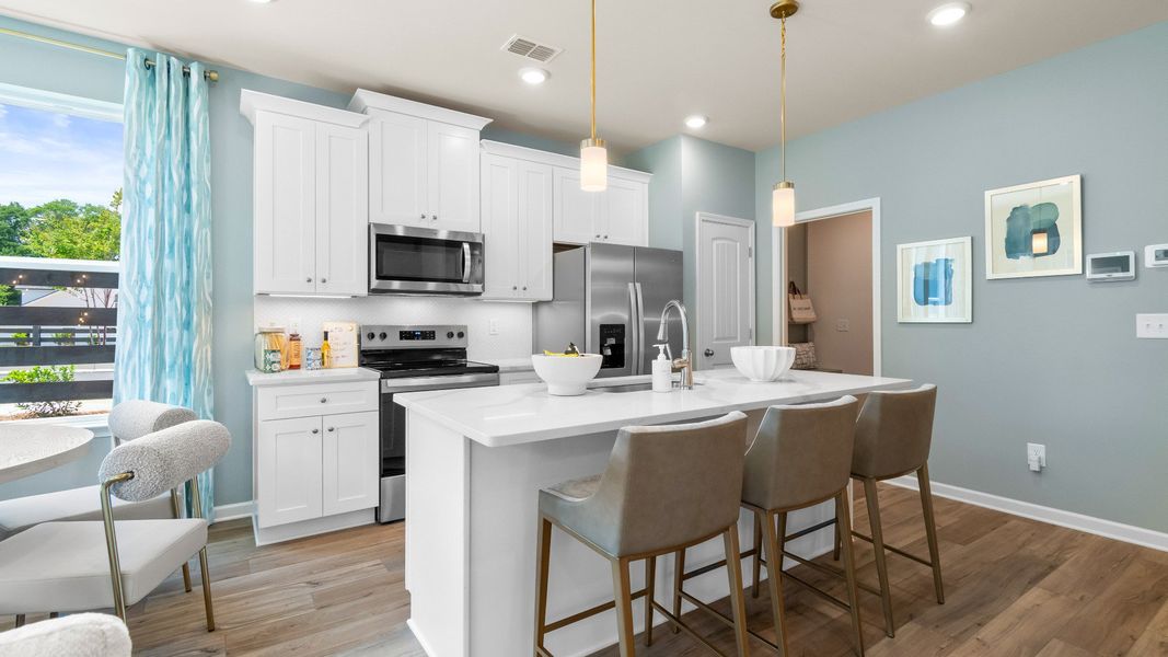 Modern kitchen with quartz island, stylish backsplash, stainless appliances, and ample cabinet storage. Modern kitchen with quartz island, stylish backsplash, stainless appliances, and ample cabinet storage.