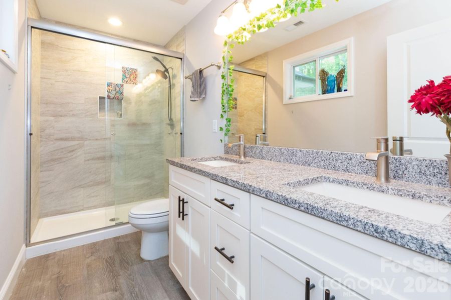 Primary bathroom with double vanity and tile shower. Primary bathroom with double vanity and tile shower.
